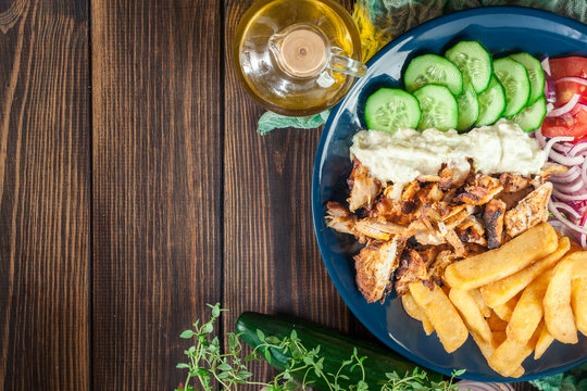 Greek gyros dish with french fries and vegetables