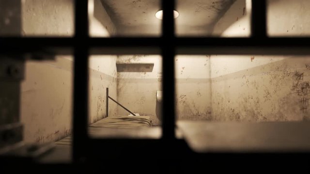 Grunge prison cell interior seen through jail bars. Horizontal camera motion.