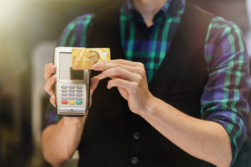 Customer making wireless or contactless payment using credit card.