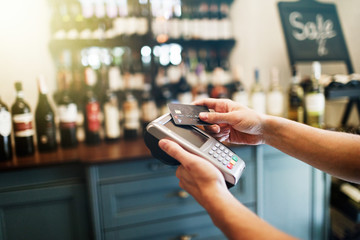 Customer making wireless or contactless payment using credit card.