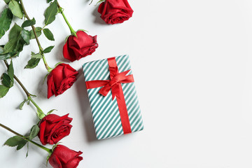 Gift box and beautiful roses on white background