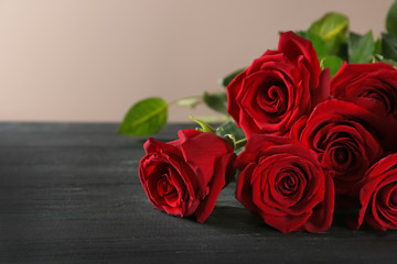 Beautiful red roses on wooden table