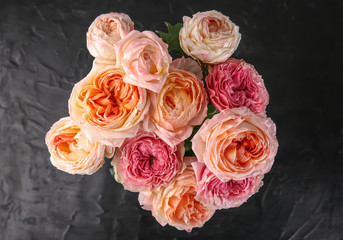 Bouquet of beautiful roses on dark textured background