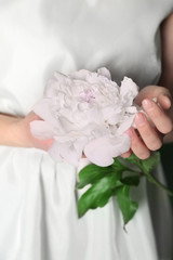 Young woman holding beautiful peony, closeup