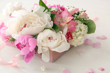 Box with beautiful flowers on white table