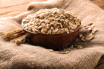 Bowl with oat flakes on sackcloth