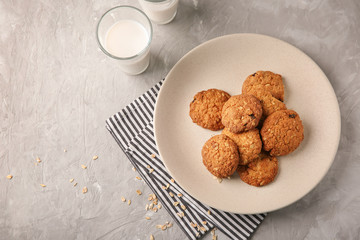 Plate with delicious oatmeal cookies on light background
