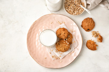 Composition with delicious oatmeal cookies and milk on light background, top view