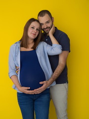 pregnant couple  isolated over yellow background