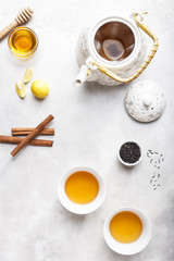 Obraz na płótnie Canvas Two Cups of Lemon Honey Cinnamon Tea and a White Kettle