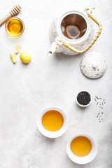 Obraz na płótnie Canvas Two Cups of Lemon Honey Tea and a White Kettle
