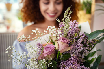 Charming flowers. Selective focus of a beautiful flower bouquet being given to an attractive young...