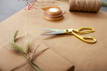Fototapeta na wymiar In the workshop. Close up of scissors lying on the table near the gift box in the flower shop