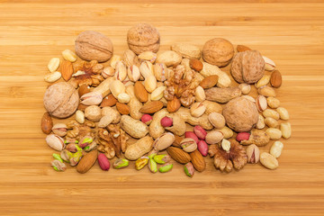 Pile of the various nuts on a bamboo wooden surface