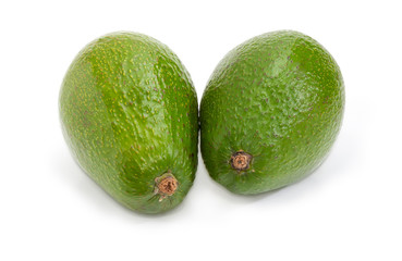 Two whole green-skinned avocado fruits on a white background