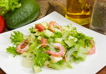 Avocado salad with vegetables, mozzarella, shrimps, closeup among some ingredient