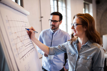 Portrait of architects discussing and drawing on board