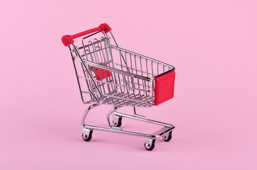 Empty shopping cart on pink background