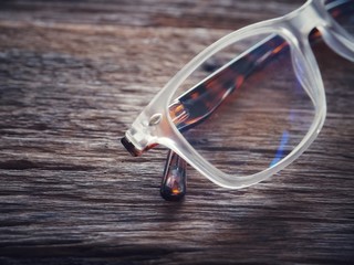 Glasses on the old wood table. And space for text or symbols in vintage tones with long-standing objects or items in memory.