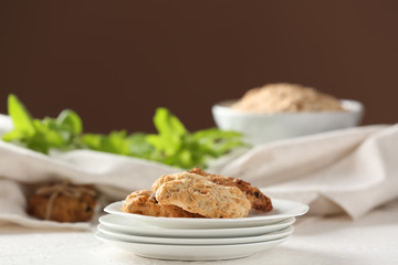Plate with delicious oatmeal cookies on table