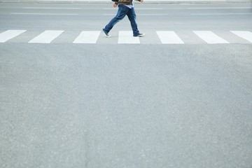 Tourist Man wear jeans walking with backpack across the crosswalk at the junction street of city, Pedestrian safety concept,  Leave space empty, write a message on the road.