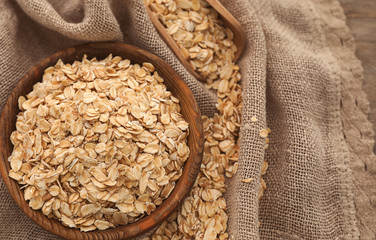 Bowl and scoop with raw oatmeal on napkin