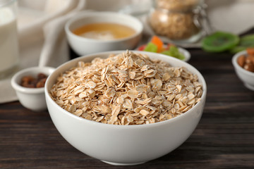 Bowl with raw oatmeal on table