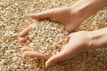 Woman with handful of raw oatmeal