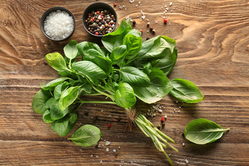 Fresh basil with spices on wooden table