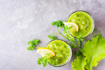 Refreshing smoothies from cucumber, green apple, fresh herbs and lemon juice in transparent glasses on the table. The concept of a healthy diet. Vegetarian menu. Top view