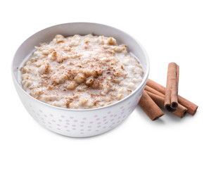 Bowl with tasty oatmeal and cinnamon on white background