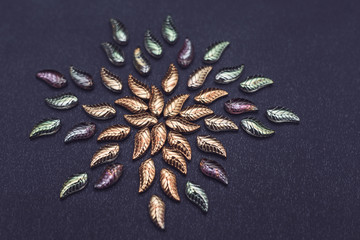 Beautiful glass leaves on a dark background fabric. Vintage background for needlework. Creative...