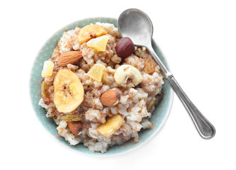 Bowl with tasty oatmeal and spoon on white background