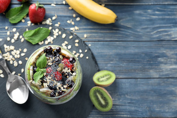 Jar with tasty oatmeal, fresh fruits and berries on table