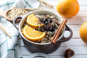 Tureen with tasty oatmeal on wooden table