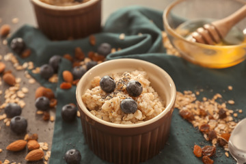 Bowl with tasty oatmeal and fresh berries on table