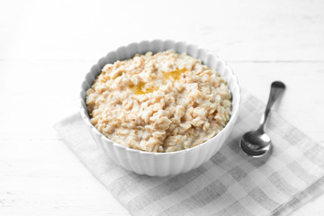 Tasty oatmeal in bowl on table
