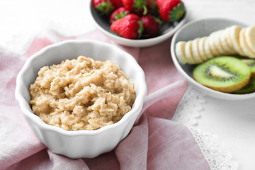 Tasty oatmeal in bowl on table
