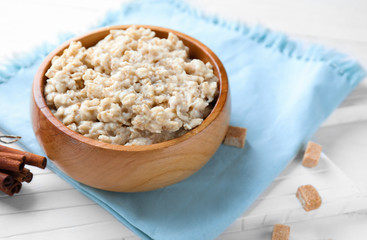 Tasty oatmeal in bowl on table