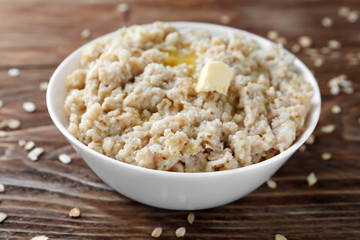 Tasty oatmeal in bowl on table