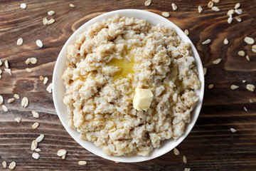 Tasty oatmeal in bowl on table