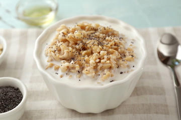 Bowl with tasty oatmeal on table