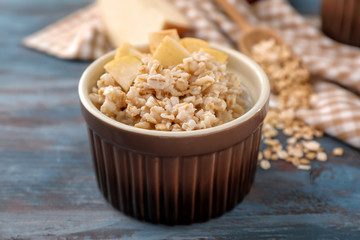 Bowl with tasty oatmeal on wooden table