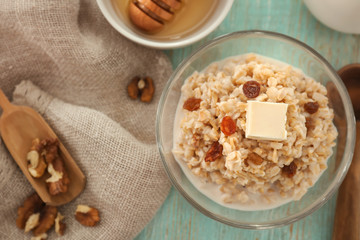 Bowl with tasty oatmeal on wooden table