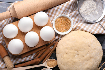 Composition with raw dough and ingredients for preparing pastries on table