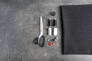 Composition with fabric and sewing accessories on dark background