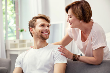 Happy motherhood. Joyful happy woman smiling while looking at her son