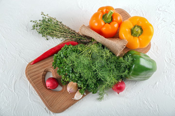 Composition with different fresh herbs and vegetables on light background