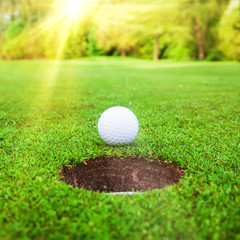 golf ball on lip of cup