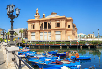 Margherita Theater and fishing row boat in old harbor of Bari, region of Apulia, Italy.